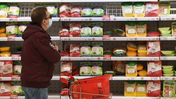Покупатель выбирает куриную грудку в гипермаркете Ашан